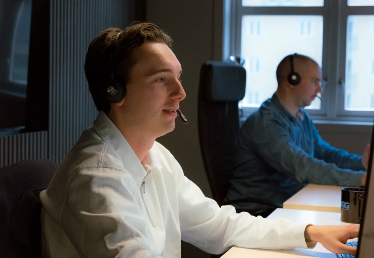 Rådgivere med headset jobber sammen i lyse kontorlokaler i Trondheim